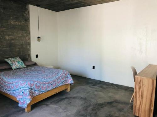a bedroom with a bed and a wooden table at Industrialhaus Alberca privada y climatizada in Ahuatepec