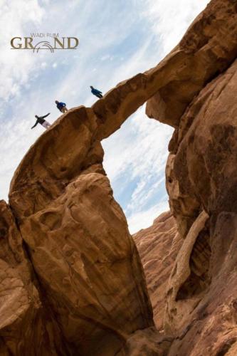 two people on a rock formation in the desert at Wadi Rum Grand in Wadi Rum