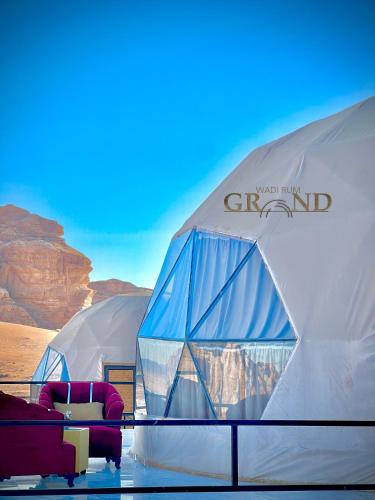 a group of tents with couches in the desert at Wadi Rum Grand in Wadi Rum