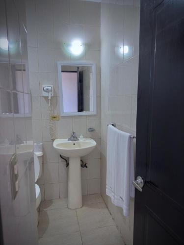 a white bathroom with a sink and a toilet at Hotel Maioris Kumate Culiacán in Culiacán