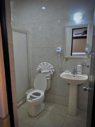 a bathroom with a toilet and a sink at Hotel Maioris Kumate Culiacán in Culiacán