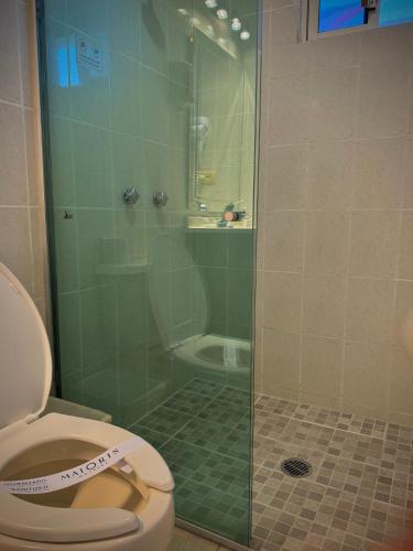 a bathroom with a glass shower with a toilet at Hotel Maioris Kumate Culiacán in Culiacán
