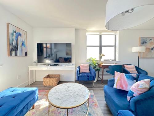 a living room with blue couches and a table at Luxury 2BR - Elevator-Gym-Laundry-10 Min to NYC in Hoboken
