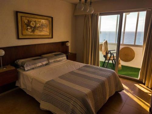 a bedroom with a bed and a view of the ocean at Edificio céntrico en el Este, Torre Gorlero in Punta del Este
