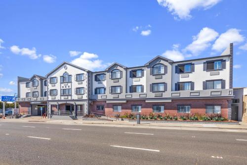 a large white building on the side of a street at Hotel Skye San Francisco Airport SFO FREE SHUTTLE! in San Bruno