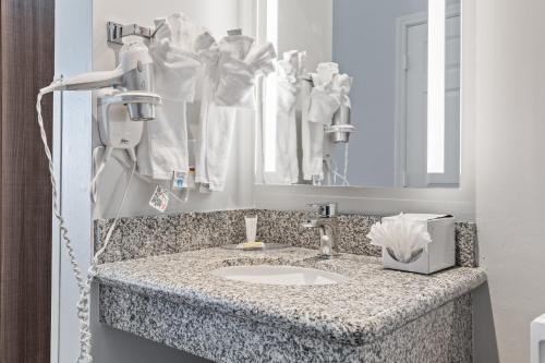 a bathroom counter with a sink and a mirror at Hotel Skye San Francisco Airport SFO FREE SHUTTLE! in San Bruno