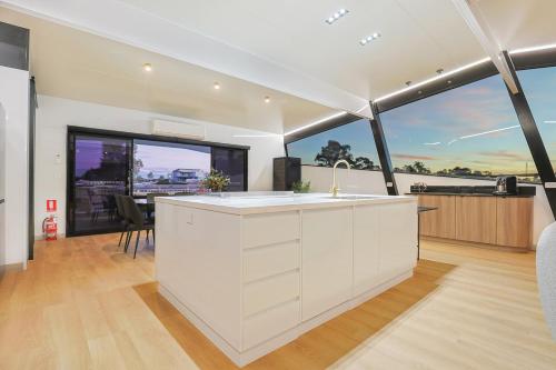 a kitchen with a white counter and large windows at All Seasons Houseboats in Mildura
