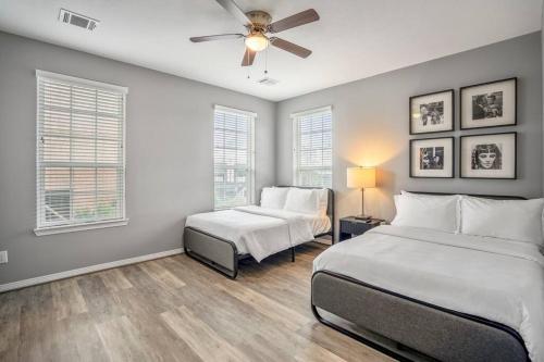 a bedroom with two beds and a ceiling fan at Vintage Hollywood Theater House in East Downtown in Houston