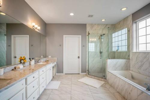 a bathroom with two sinks and a tub and a shower at Vintage Hollywood Theater House in East Downtown in Houston