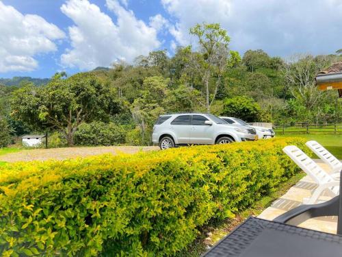 a silver car parked in a yard next to a hedge at 15 mins to Jardín Spacious & Convenient House in Los Andes