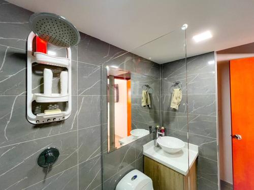 a bathroom with a toilet and a sink and a mirror at 15 mins to Jardín Spacious & Convenient House in Los Andes