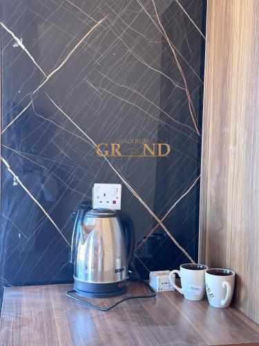 a coffee maker and two cups on a table at Wadi Rum Grand in Wadi Rum