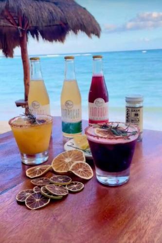 a table with three bottles of drinks on a beach at Akumal Amor Caribbean Sea View 2 Min Walk To Beach in Akumal