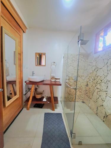 a bathroom with a glass shower and a sink at Colibrí Villa, 800 m from Beach in Uvita