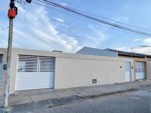 皮拉尼亚斯Casa Valentina Piranhas-AL的白色的建筑,在街上有两扇车库门
