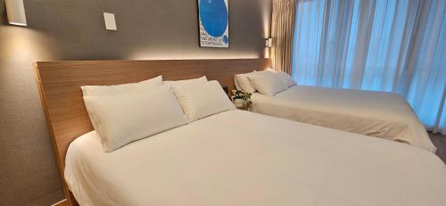 a hotel room with two beds and a window at Haeundae Ocean Family in Busan