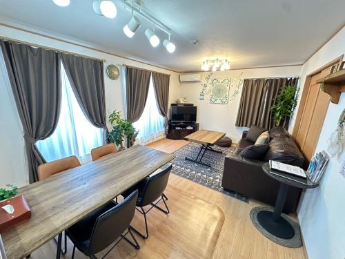 a living room with a large wooden table and chairs at Laulea in Yaka