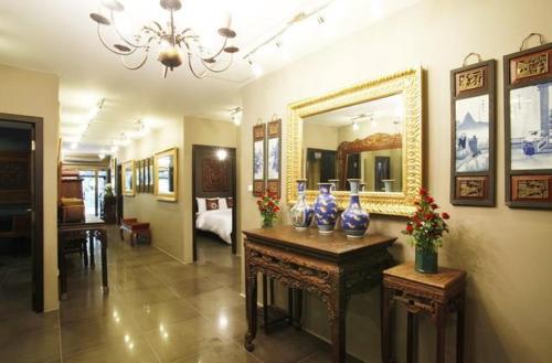 チェンマイにあるリル チェンマイの鏡と花瓶が置かれたテーブルが備わる部屋