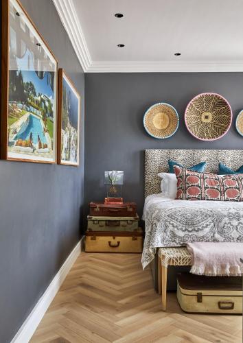 a bedroom with blue walls and a bed with pillows at Pineapple House Boutique Hotel in Cape Town