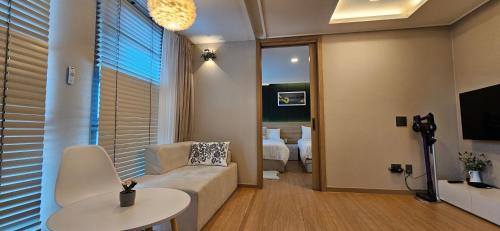 a living room with a couch and a table at Haeundae Ocean Family in Busan