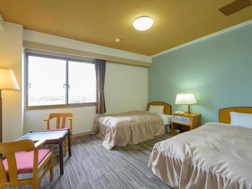 Postel nebo postele na pokoji v ubytování Hisai Green Hotel