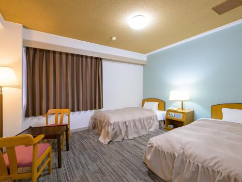 Postel nebo postele na pokoji v ubytování Hisai Green Hotel