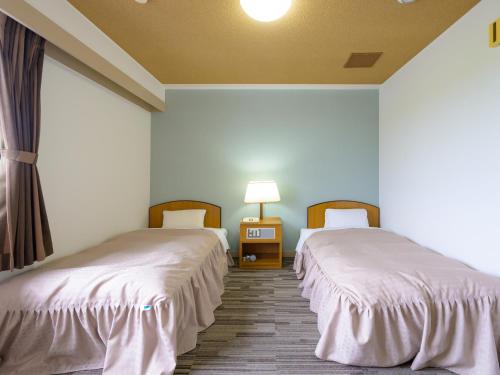 Postel nebo postele na pokoji v ubytování Hisai Green Hotel