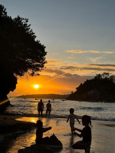 a group of people playing on the beach at sunset at Meket Bungalows in Nusa Penida