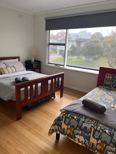a bedroom with two beds and a large window at Southern Ocean Retreat in Warrnambool
