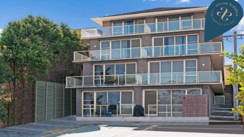 an apartment building with balconies and a sign that says synergy apartments at Beachside #7 Close To Beach Accom Holidays in Wamberal