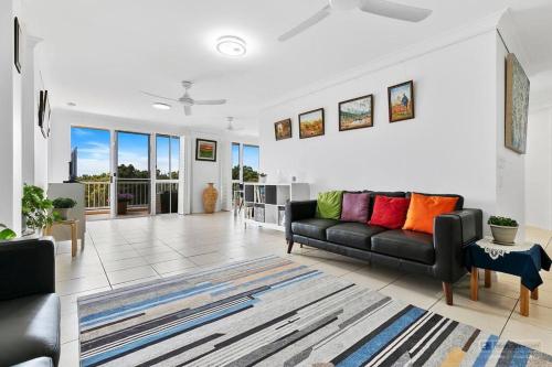 a living room with a black couch and a rug at Penthouse on Woorim in Woorim