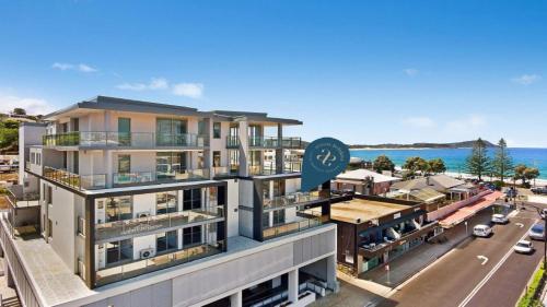 特里格尔Oceans Edge #7 Accom Holidays的背景中带有海洋的建筑的形象