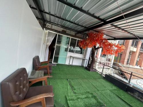 a room with a balcony with green grass and chairs at Patong Terrace Hotel in Patong Beach