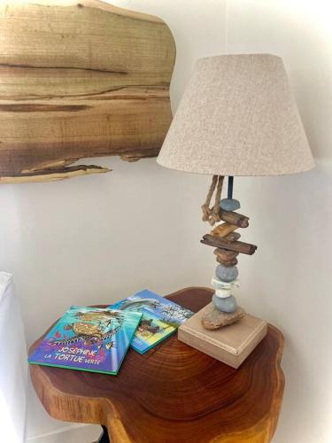 a table with a lamp and books on it at Te Miti - Tropical paradise retreat in Paea