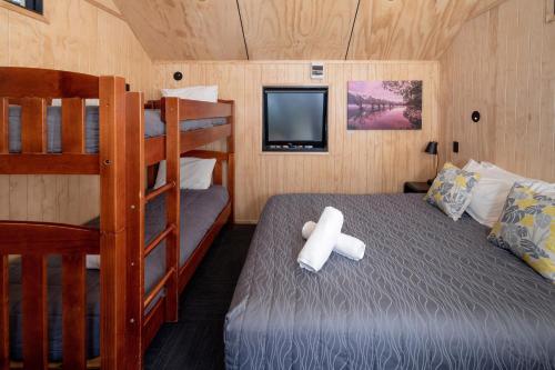 a bedroom with two bunk beds and a television at Queenstown Top 10 Holiday Park in Queenstown