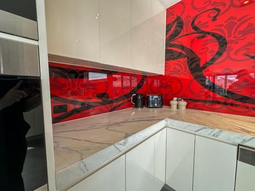 una cucina con una parete rossa e nera di Luxury Stay in Premium Penhouse a Melbourne