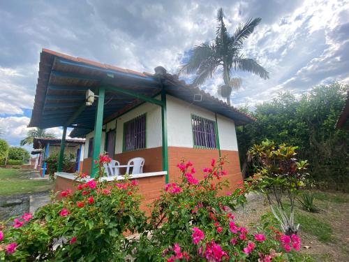 a small house with flowers in front of it at FINCA HOTEL LAS CABAÑAS DEL Parque in Pueblo Tapao