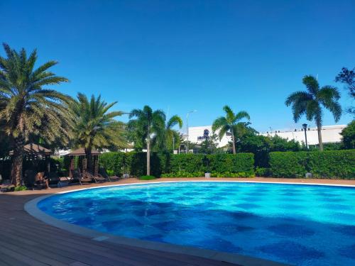 a large swimming pool with palm trees in the background at 2br condo in Southmall Las Pinas 25 mins to NAIA - 709T3 in Manila