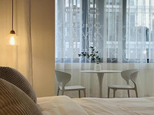 a bedroom with a table and chairs and a window at WillsChengduCenter in Chengdu