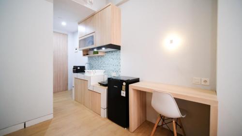 a kitchen with a counter and a chair in a room at Good Location and New Studio at The City Square Surabaya Apartment By Travelio in Bendulmrisi