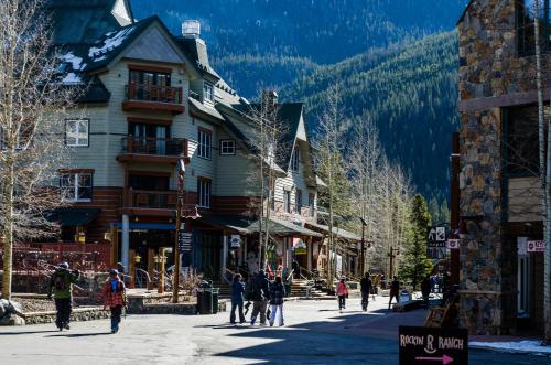 a group of people walking down a street in a ski resort at Trapper's Crossing by Summit County Mountain Retreats in Keystone