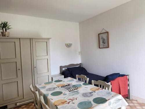 une salle à manger avec une table et un canapé dans l'établissement Studio avec jardin, balcon, WIFI et parking près des Thermes - FR-1-541-117, à La Roche-Posay