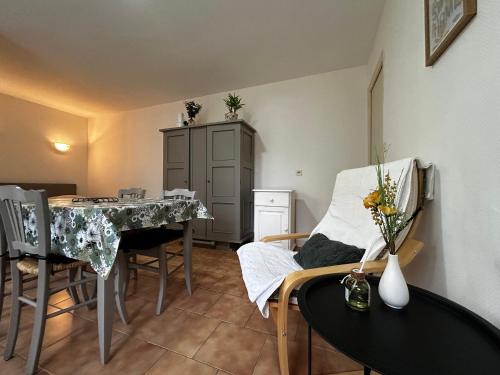 un salon avec une table et des chaises et une cuisine dans l'établissement Charmant studio près des Thermes avec jardin et wifi - FR-1-541-118, à La Roche-Posay