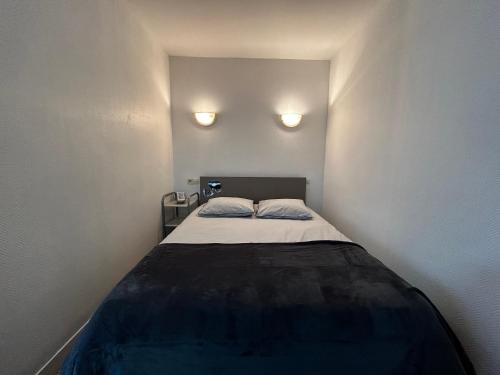 - un petit lit dans une petite chambre avec deux lumières dans l'établissement Charmant studio près des Thermes avec jardin et wifi - FR-1-541-118, à La Roche-Posay