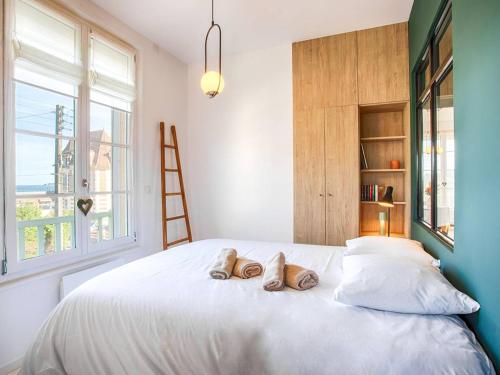 une chambre avec un lit avec deux paires de chaussures dessus dans l'établissement Superbe appartement rénové à Cabourg, face à la mer pour 2 - FR-1-788-33, à Cabourg