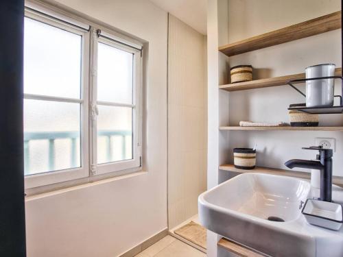 une salle de bain avec un lavabo et une fenêtre dans l'établissement Superbe appartement rénové à Cabourg, face à la mer pour 2 - FR-1-788-33, à Cabourg