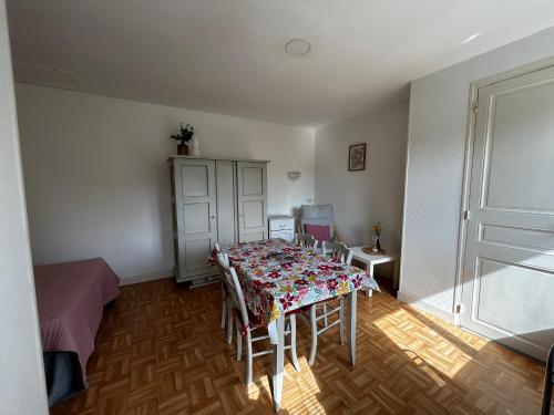 Cette chambre comprend une table avec des chaises et un lit. dans l'établissement Studio avec jardin commun et WIFI proche centre-ville et Thermes - FR-1-541-120, à La Roche-Posay