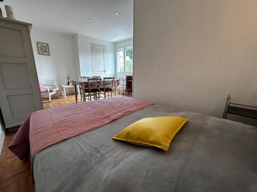 - une chambre avec un lit doté d'un oreiller jaune dans l'établissement Studio avec jardin commun et WIFI proche centre-ville et Thermes - FR-1-541-120, à La Roche-Posay