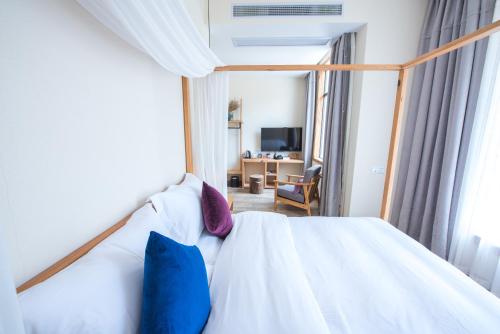 a bedroom with a white bed with blue and purple pillows at Yunshan Villa in Huangshan Scenic Area