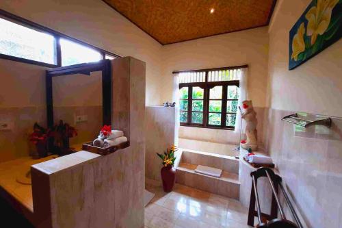 a bathroom with a shower and a tub and a window at Gitali 1 BR Superior Garden View ZN244 in Ubud